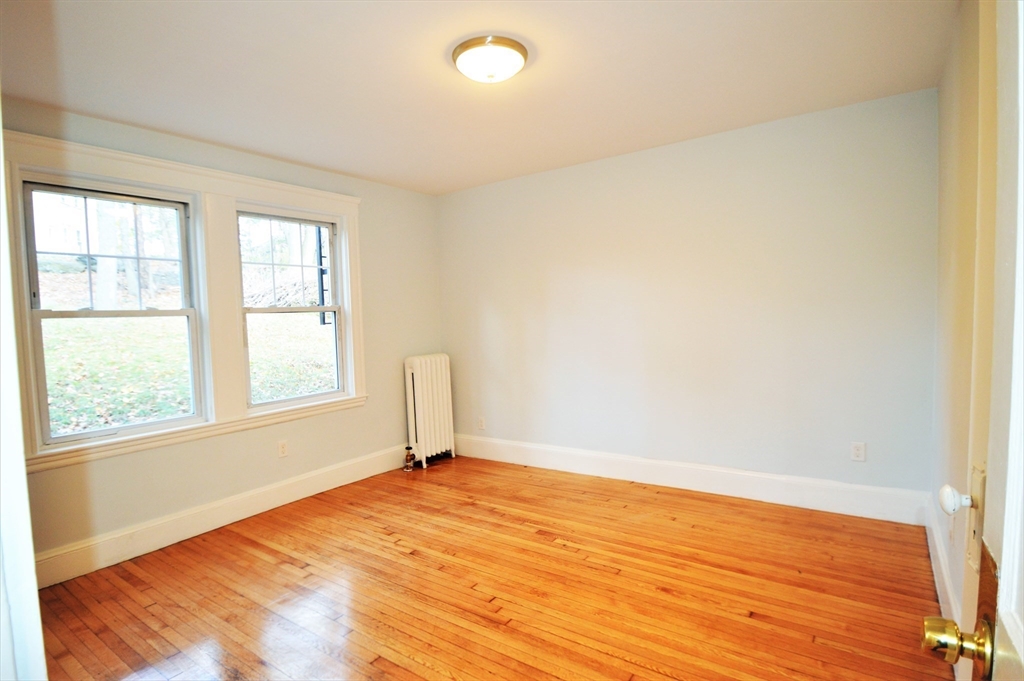 51 Leamington Road, Unit 1 Boston, MA 02135 - Photo 5 of 12 an empty room with wooden floor and windows