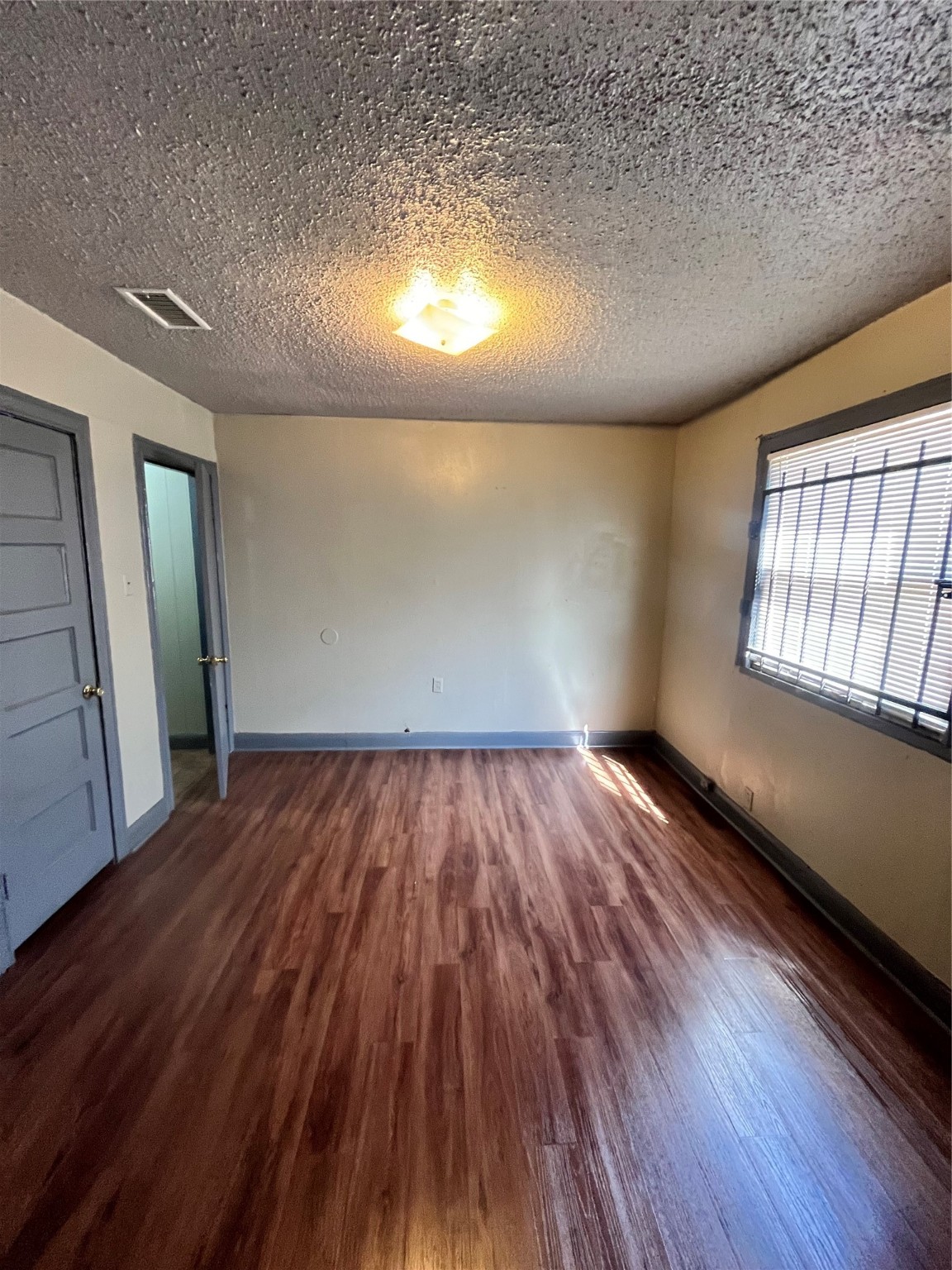 4609 Dabney Street Houston, TX 77026 - Photo 18 of 19 an empty room with wooden floor and windows