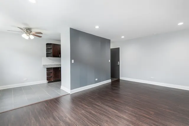 a view of an empty room with a fireplace and wooden floor