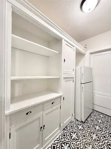 a kitchen with a refrigerator and cabinets