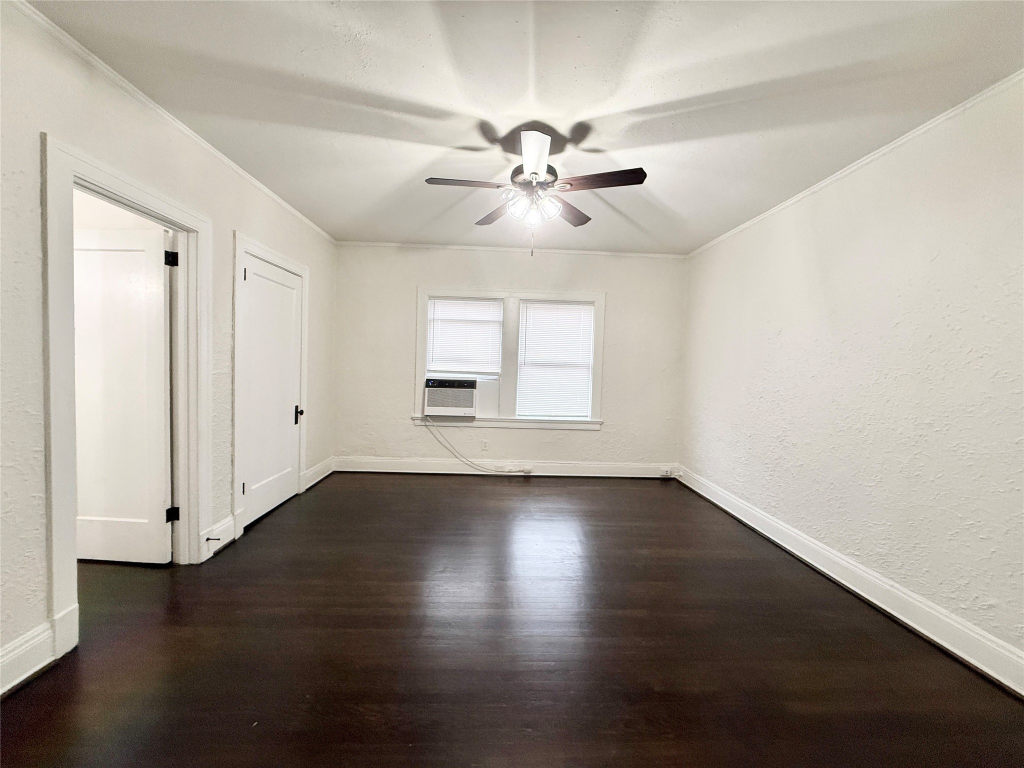 3920 Fannin Street, Unit 103 Houston, TX 77004 - Photo 5 of 24 an empty room with wooden floor chandelier fan and windows