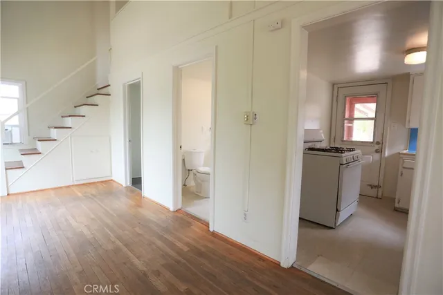 a view of a hallway with wooden floor and a living room