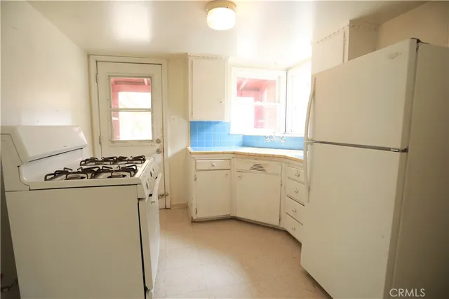 a white refrigerator freezer and a stove sitting inside of a kitchen