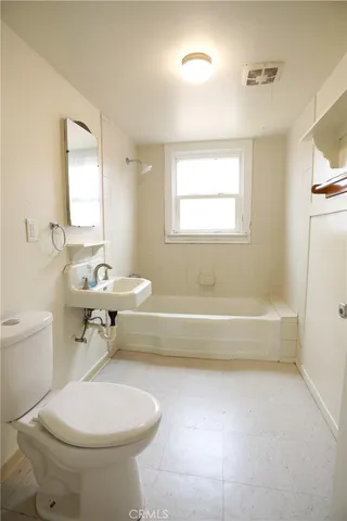 a bathroom with a toilet a sink and bathtub