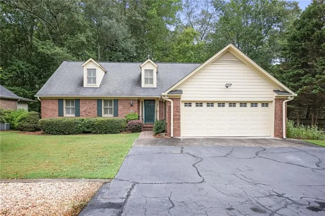 a view of a house with a yard and potted plants