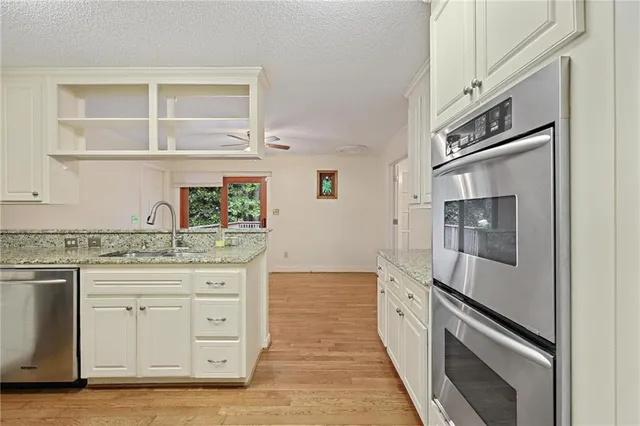 a kitchen with granite countertop cabinets stainless steel appliances and a granite counter tops