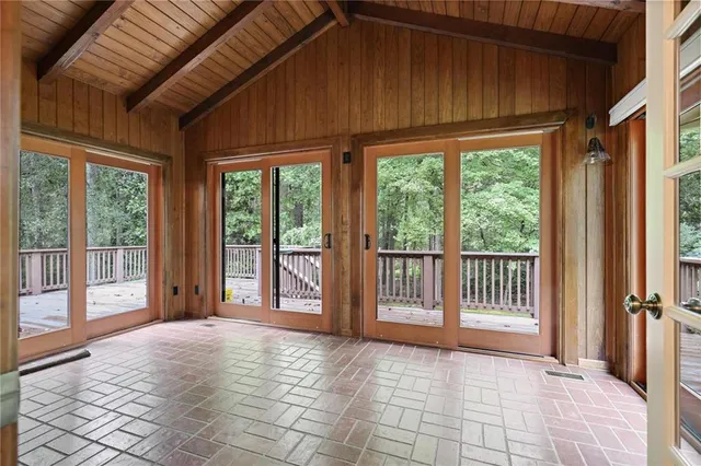a view of a room that has a bed and wooden floor