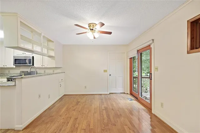 a view of a kitchen with a sink and dishwasher with wooden floor
