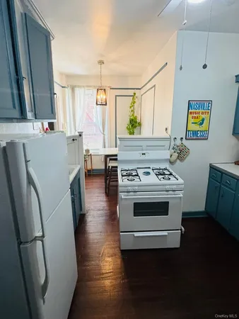 a view of kitchen with sink and refrigerator