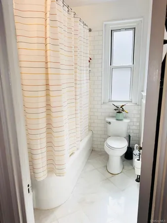 a bathroom with a toilet and a shower curtain