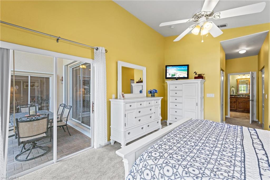 96 Glen Eagle Circle Naples, FL 34104 - Photo 12 of 33 a bedroom with a bed and a chandelier