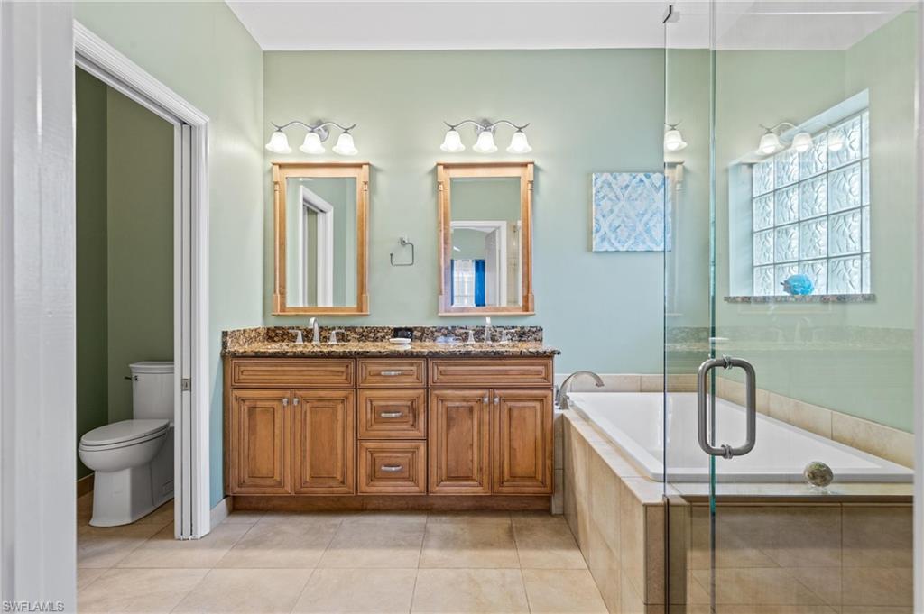 96 Glen Eagle Circle Naples, FL 34104 - Photo 13 of 33 a bathroom with a granite countertop sink and a mirror