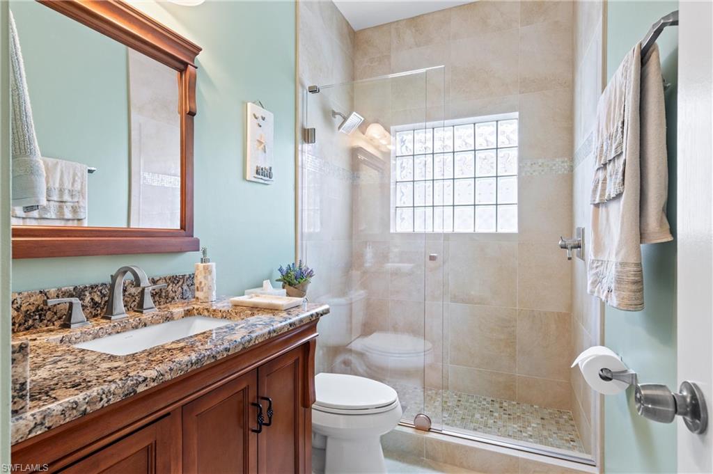 96 Glen Eagle Circle Naples, FL 34104 - Photo 16 of 33 a bathroom with a granite countertop sink toilet and shower