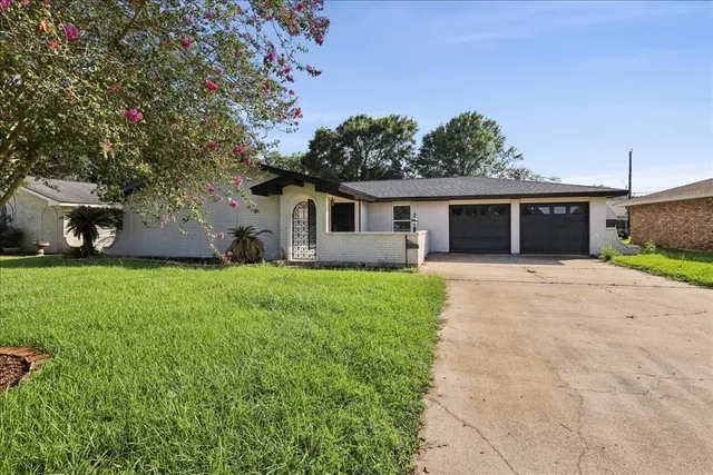 a front view of house with a garden and patio