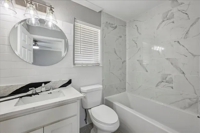 a bath room with a toilet a sink and a bath tub