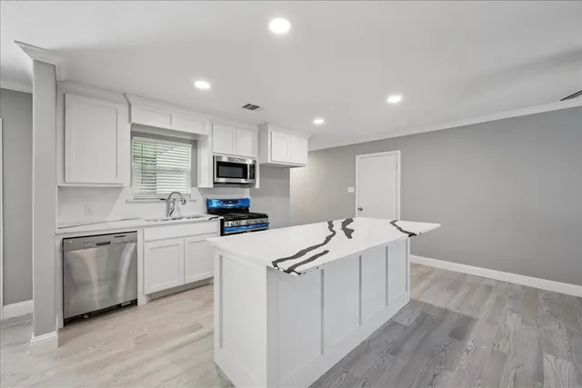 a kitchen with appliances a sink and cabinets