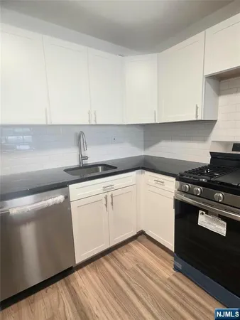 a kitchen with granite countertop white cabinets and white appliances
