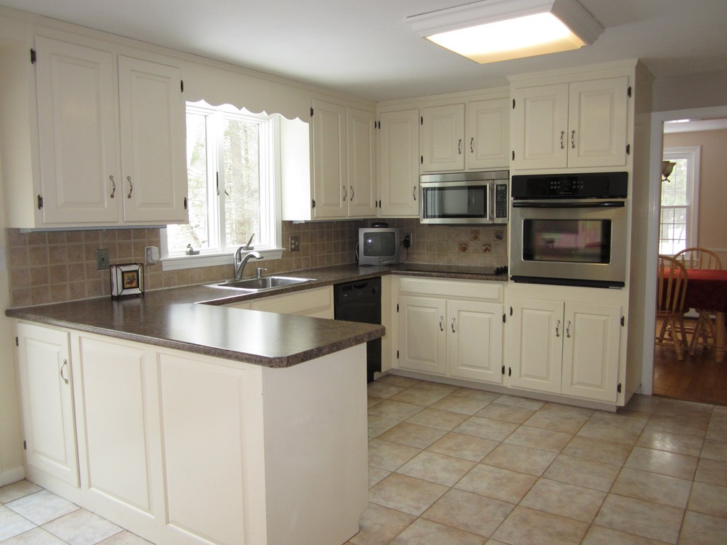 27 Janes Road Boxford, MA 01921 - Photo 4 of 15 a kitchen with granite countertop a sink a counter top space appliances and cabinets