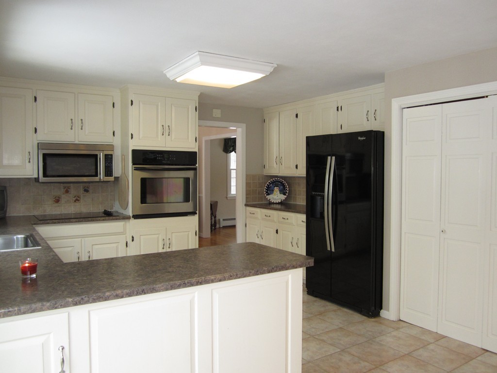 27 Janes Road Boxford, MA 01921 - Photo 5 of 15 a kitchen with stainless steel appliances white cabinets and a refrigerator