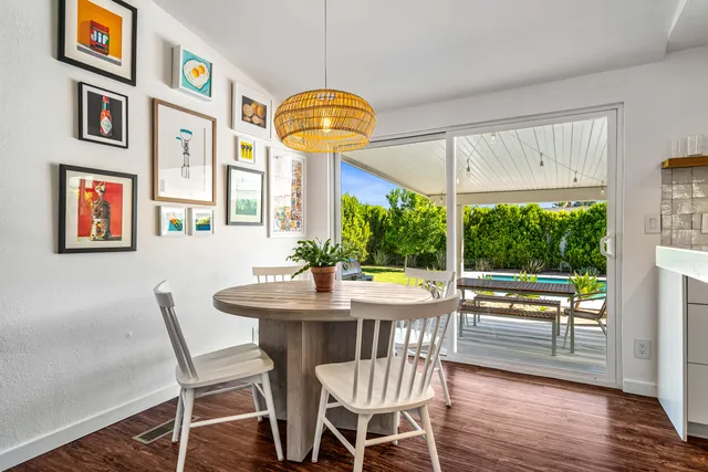 a dining room with furniture a large window and wooden floor