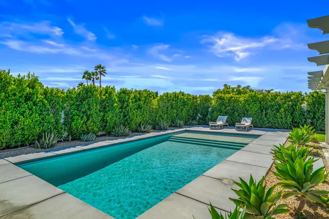 a couple of lawn chairs sitting next to a yard