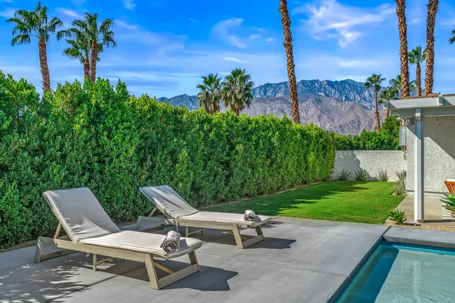 a view of a swimming pool with lounge chairs in patio