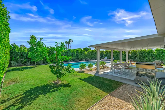a view of a patio with lawn chairs floor to ceiling window and wooden floor