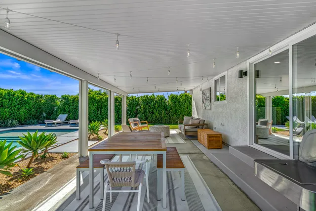 a patio with lawn chairs and wooden floor