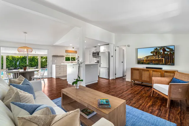 a living room with furniture stove and a large window