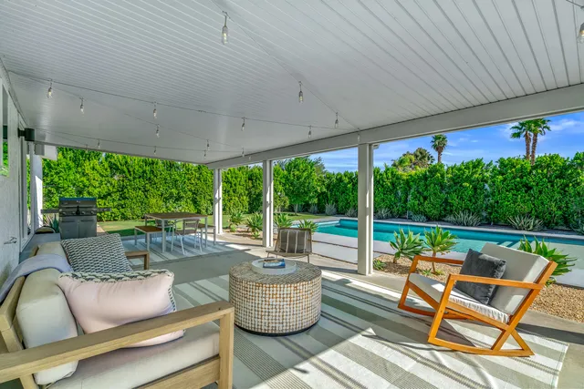 a front view of a house with a garden and mountain view