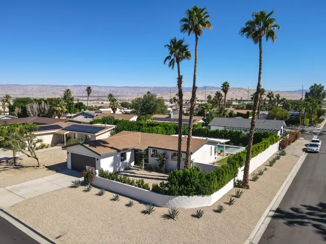 an aerial view of a house with a yard and outdoor seating