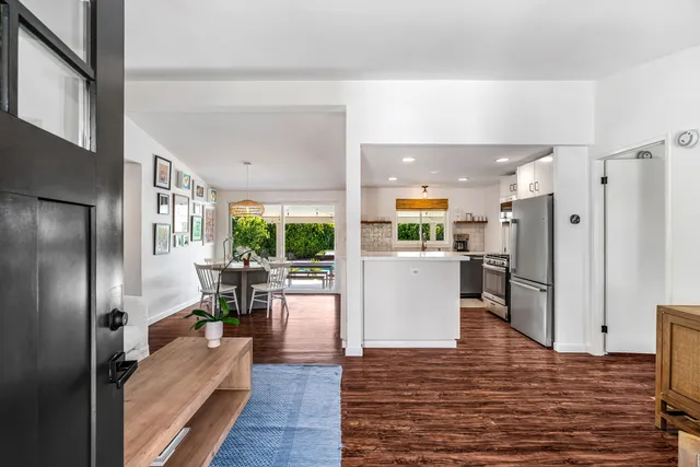 a view of kitchen with refrigerator and wooden floor