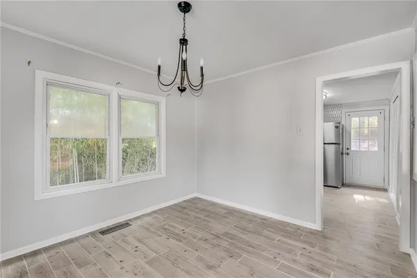 a view of empty room with wooden floor and window