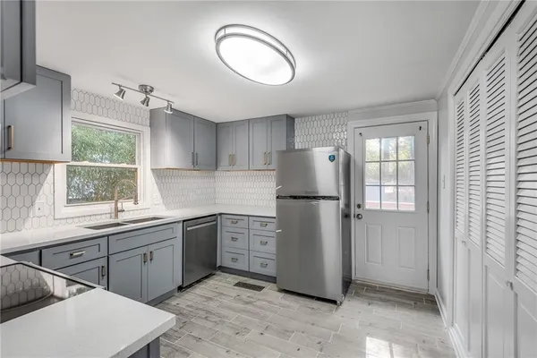 a kitchen with a refrigerator sink and cabinets