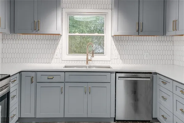 a kitchen with white cabinets and a window
