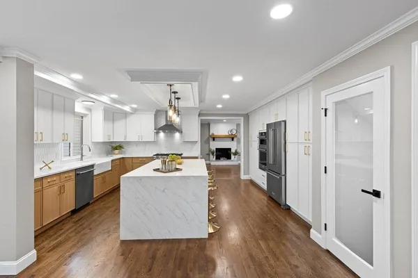 a large kitchen with a table and stainless steel appliances