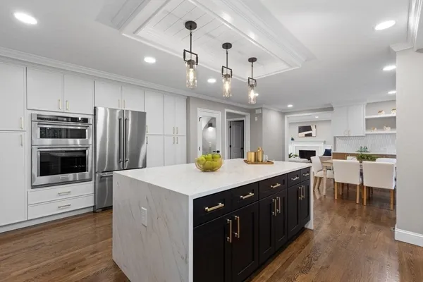 a kitchen with stainless steel appliances granite countertop a sink a stove and a refrigerator