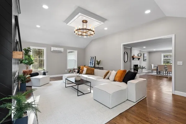 a living room with furniture kitchen view and a large window