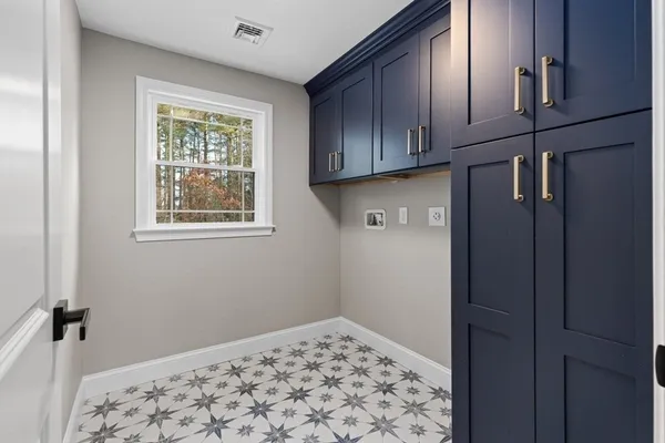 a view of an empty room with wooden floor and cabinets