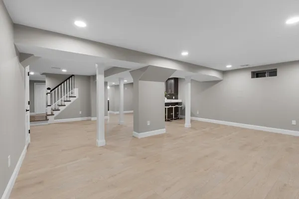 an empty room with wooden cabinet and windows
