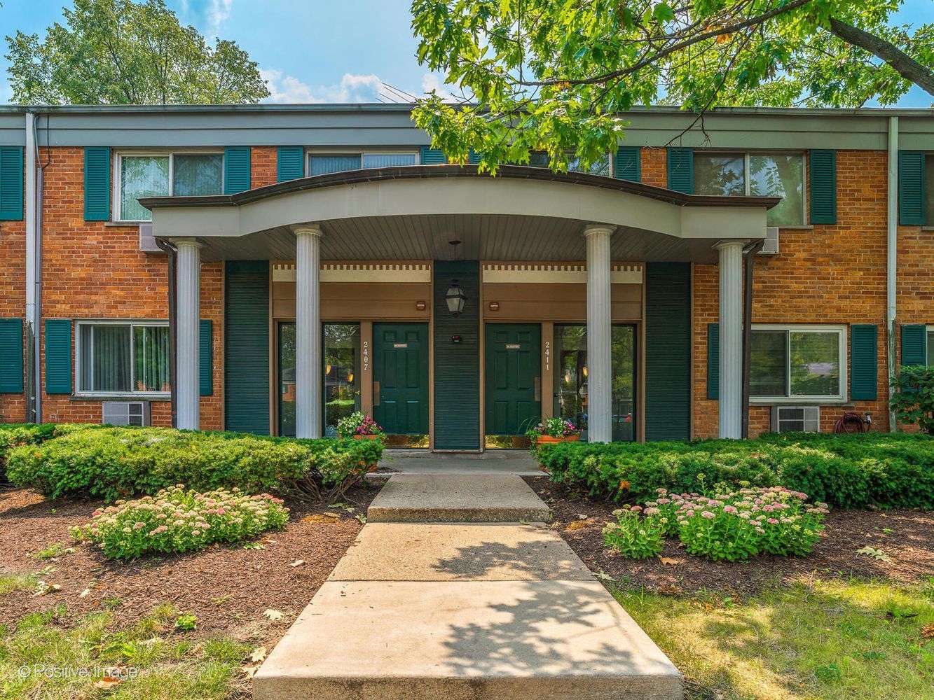front view of a brick house with potted plants