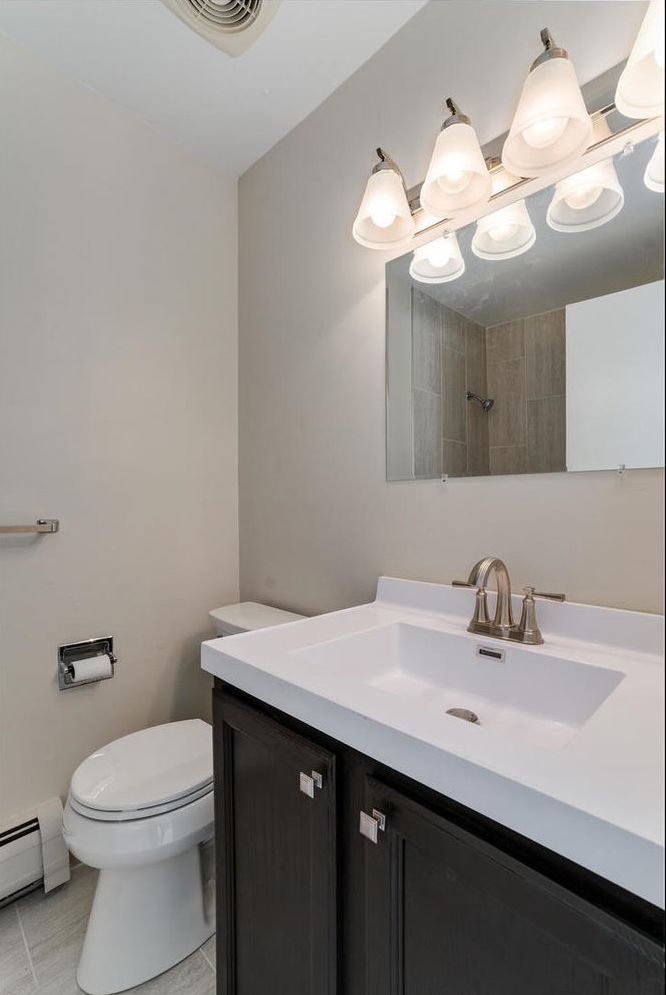 2407 South Goebbert Road, Unit 201 Arlington Heights, IL 60005 - Photo 14 of 22 a bathroom with a sink a toilet and a mirror