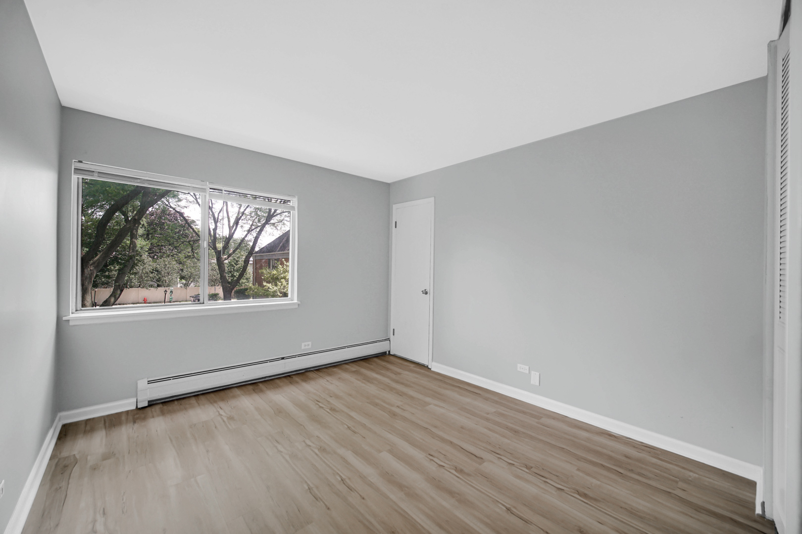 2407 South Goebbert Road, Unit 201 Arlington Heights, IL 60005 - Photo 16 of 22 a view of an empty room with wooden floor and a window