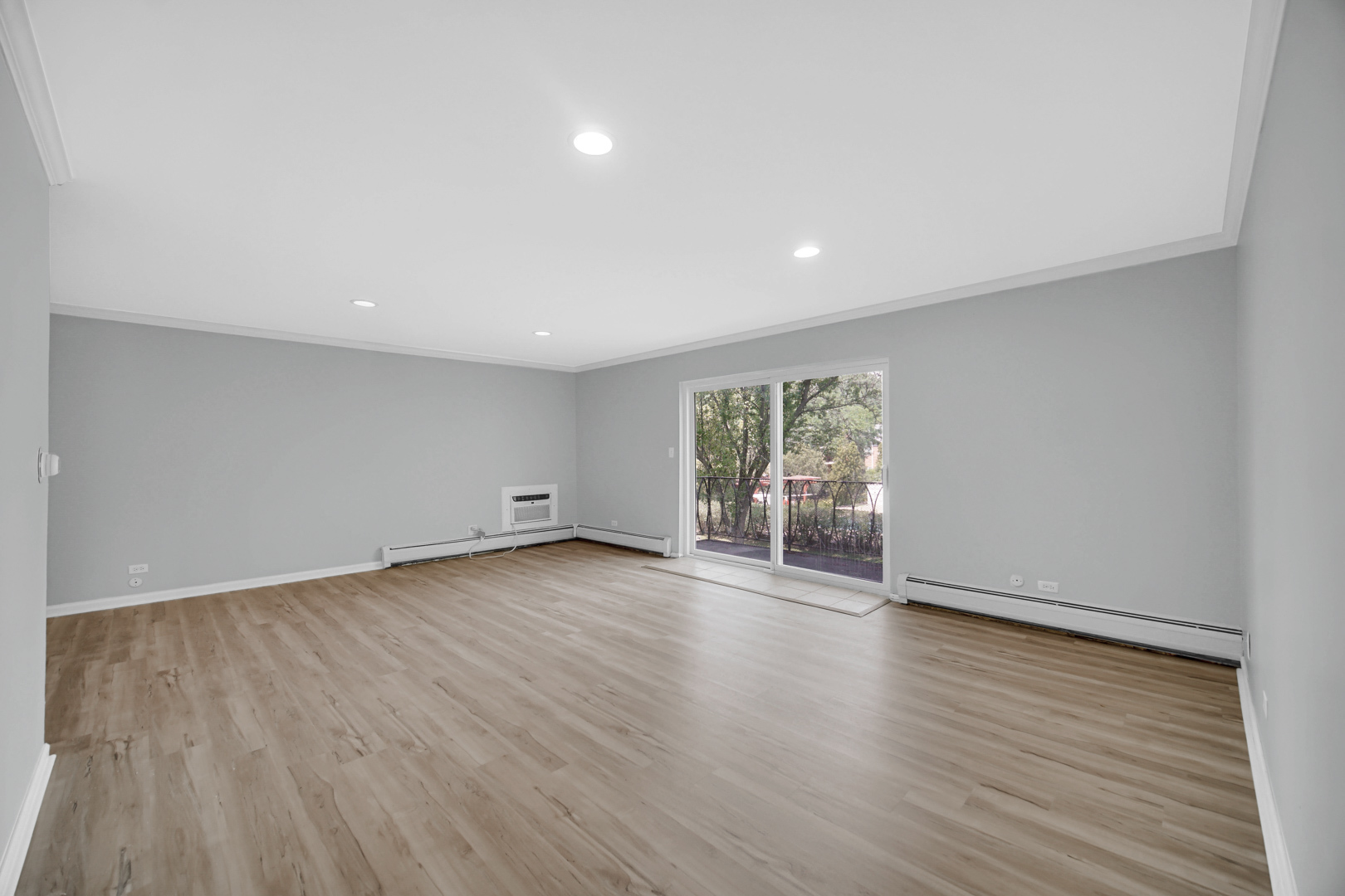 2407 South Goebbert Road, Unit 201 Arlington Heights, IL 60005 - Photo 3 of 22 a view of an empty room with wooden floor and a window