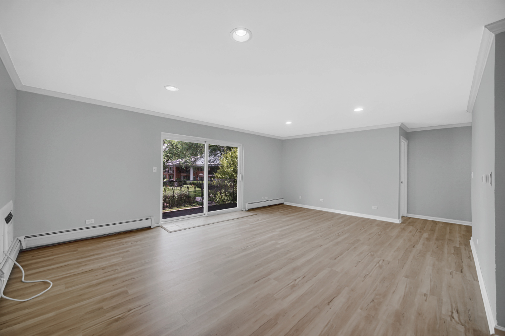 2407 South Goebbert Road, Unit 201 Arlington Heights, IL 60005 - Photo 5 of 22 a view of an empty room with wooden floor and a window