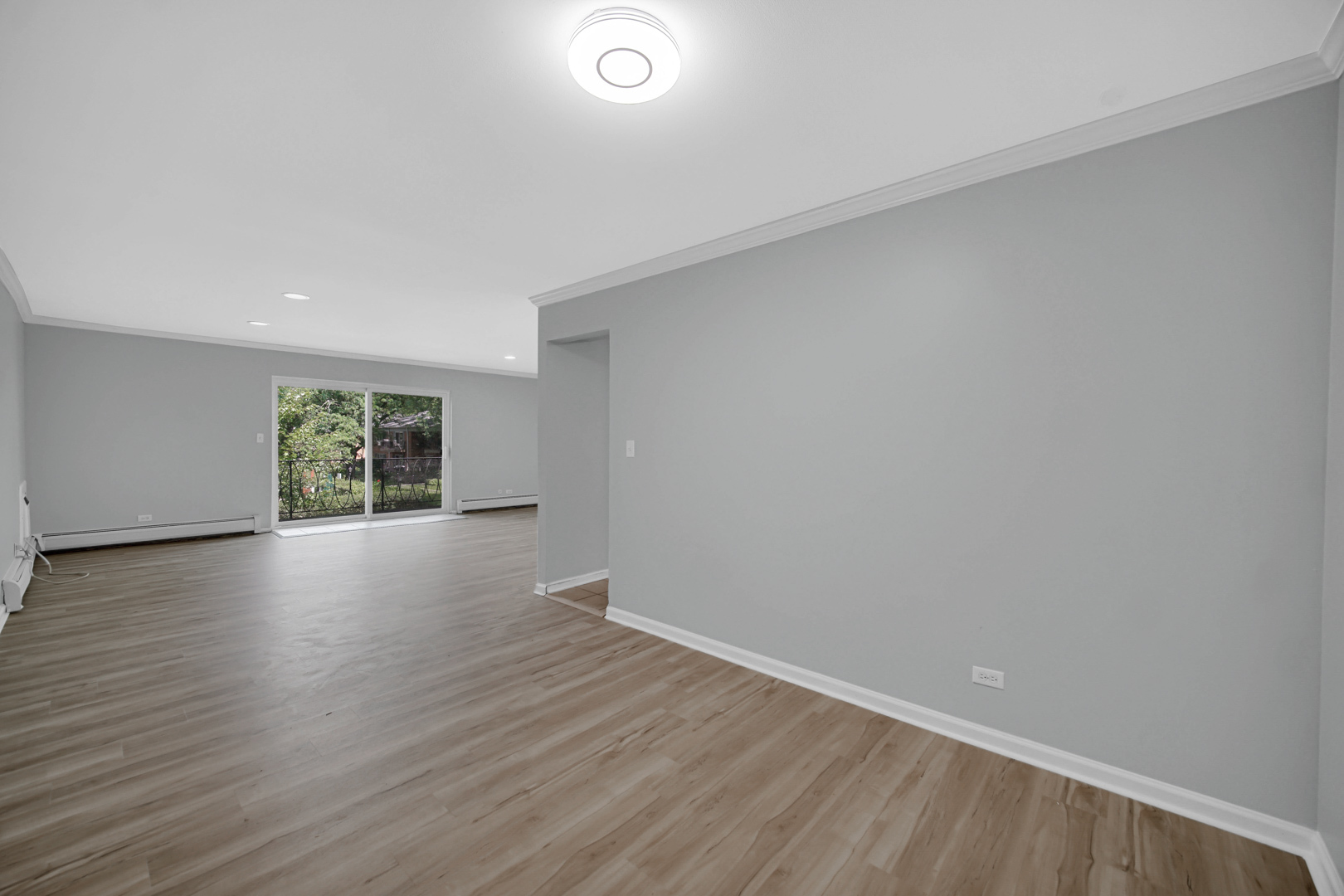 2407 South Goebbert Road, Unit 201 Arlington Heights, IL 60005 - Photo 6 of 22 a view of an empty room with wooden floor and a window