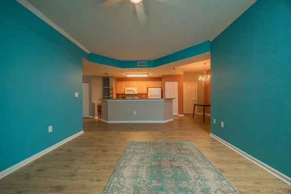 a view of a kitchen with kitchen island stainless steel appliances wooden floor and chair