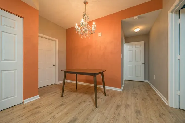a room with table chairs and wooden floor