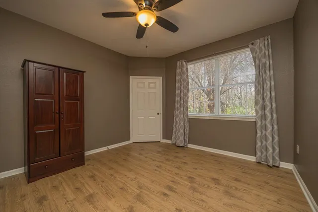 an empty room with wooden floor and closet area