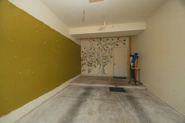 a front view of a house with garden and trees